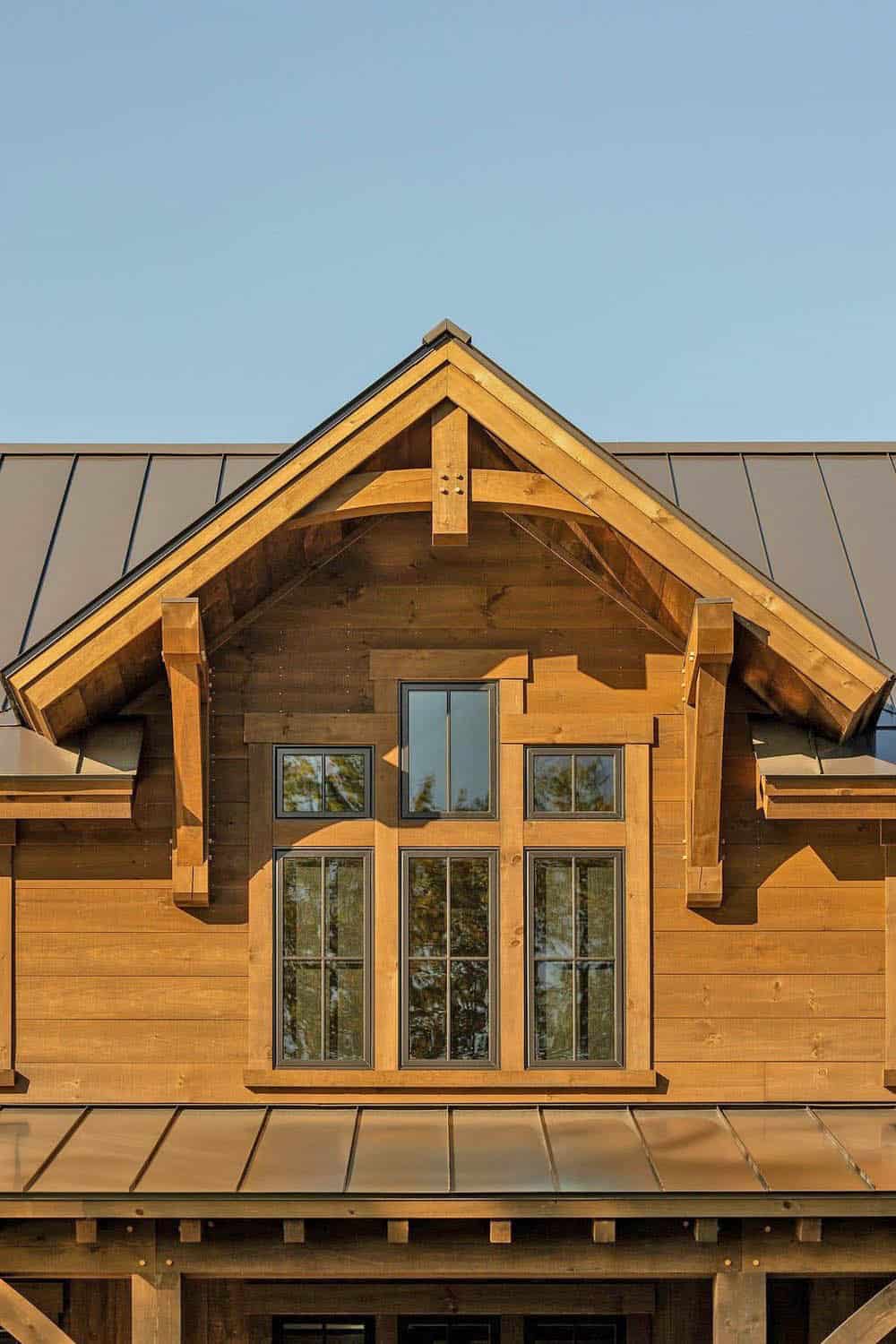 Close-up of gable peak with timber trusses and black-framed windows