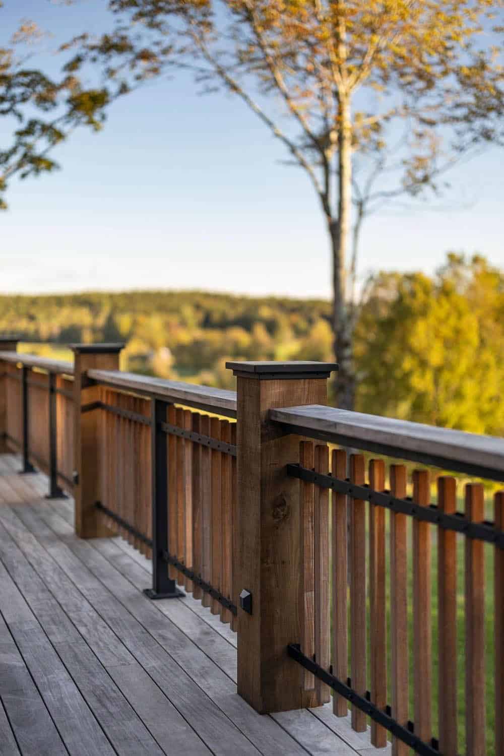 Close-up of wood and metal deck railing overlooking fall foliage and rolling hills
