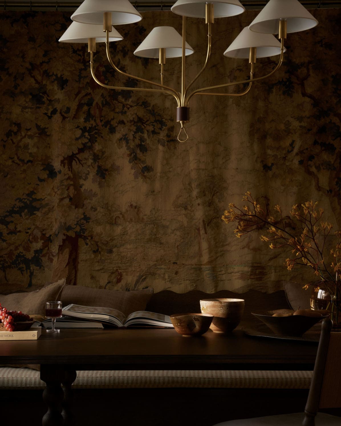 Close-up of brass chandelier against antique tapestry backdrop