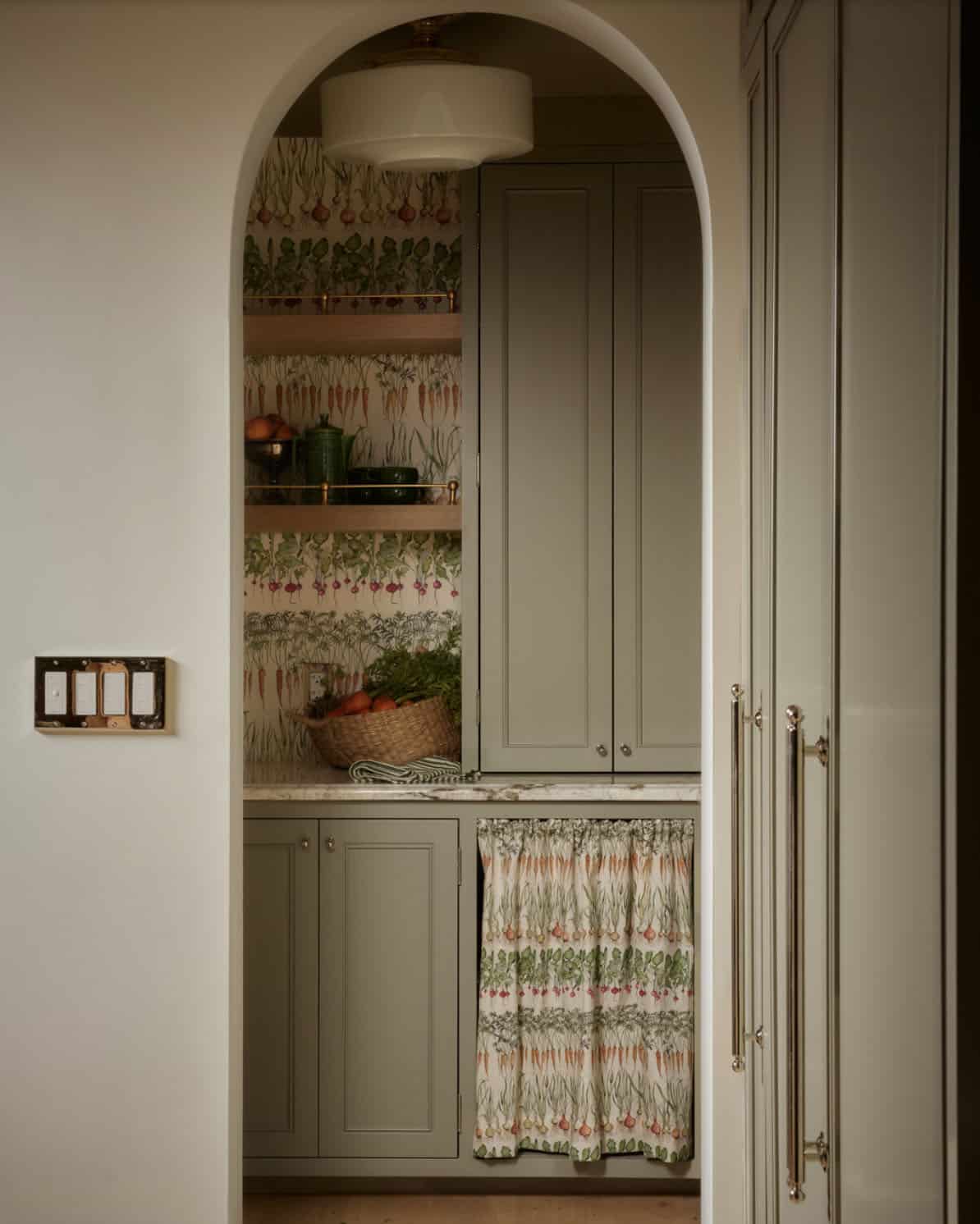 Arched pantry alcove with vegetable-print wallpaper and open shelving