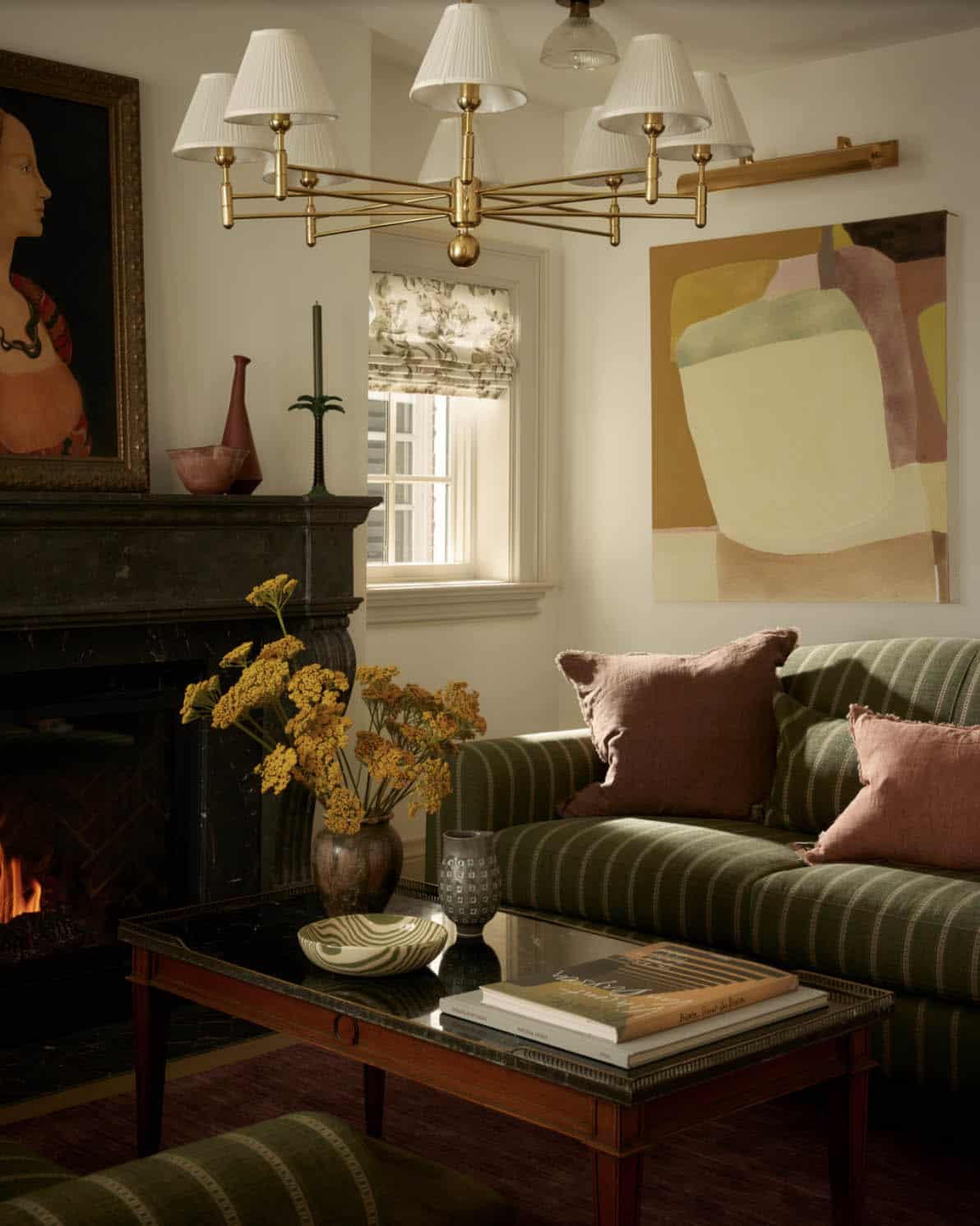 Living room seating area with brass chandelier and abstract artwork