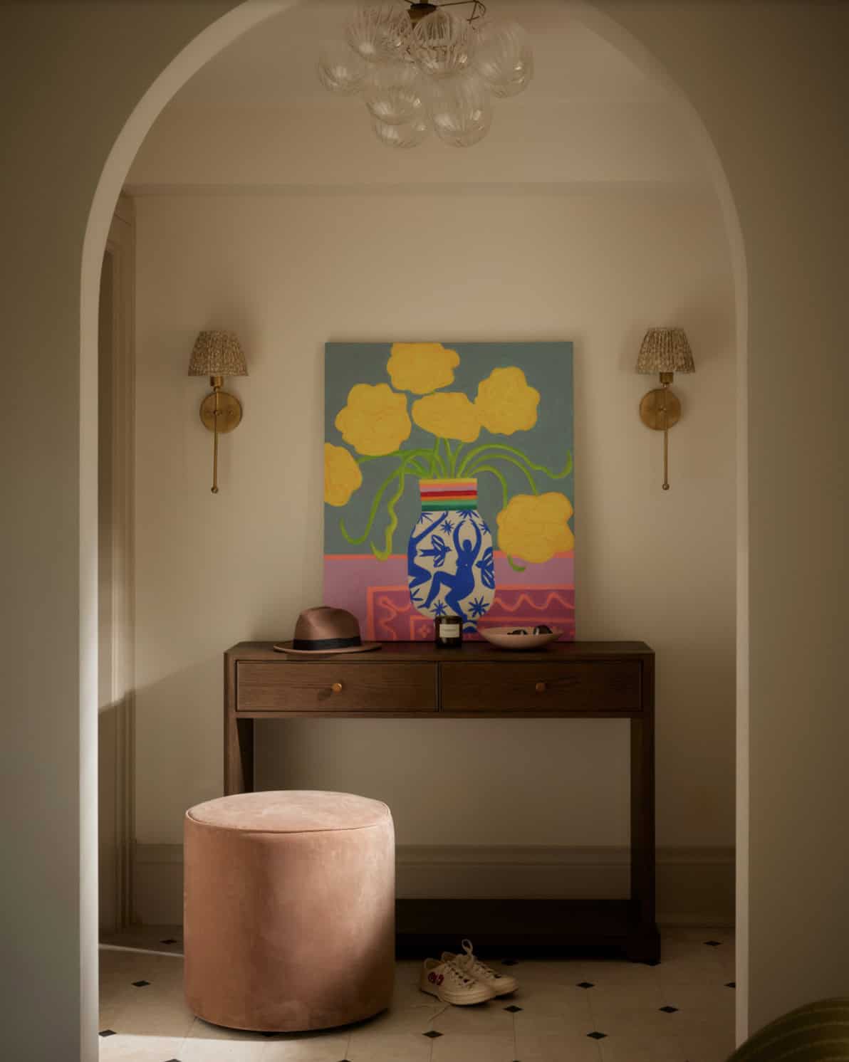 Console table vignette with floral painting under arched doorway