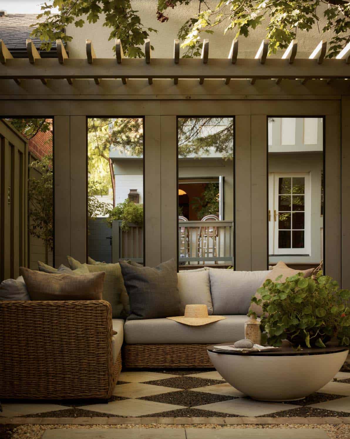 Screened outdoor lounge with wicker sofa and pergola roof