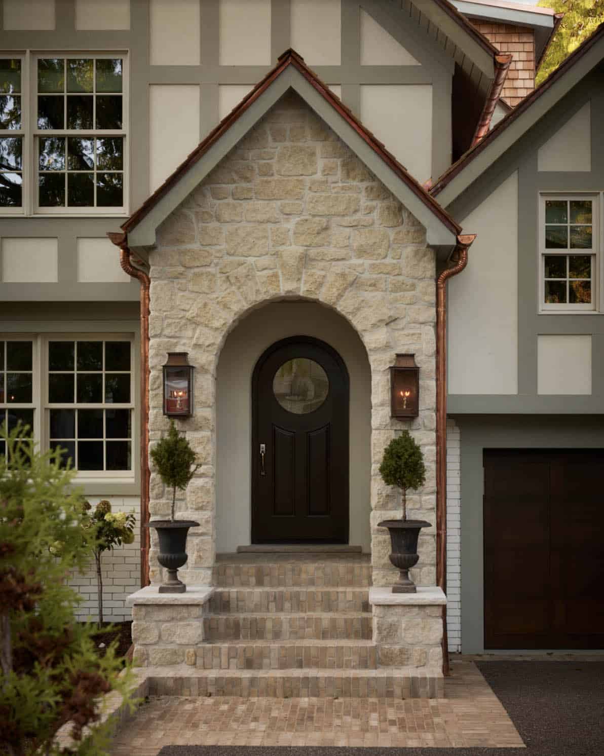 Close-up of stone archway entrance with copper roofline and lanterns