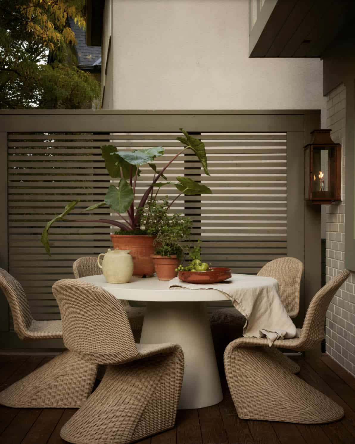 Outdoor dining set with woven chairs on wood deck