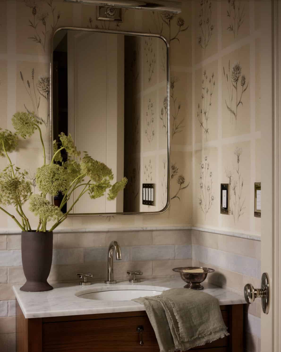 Close-up of botanical wallpaper and marble vanity in powder room