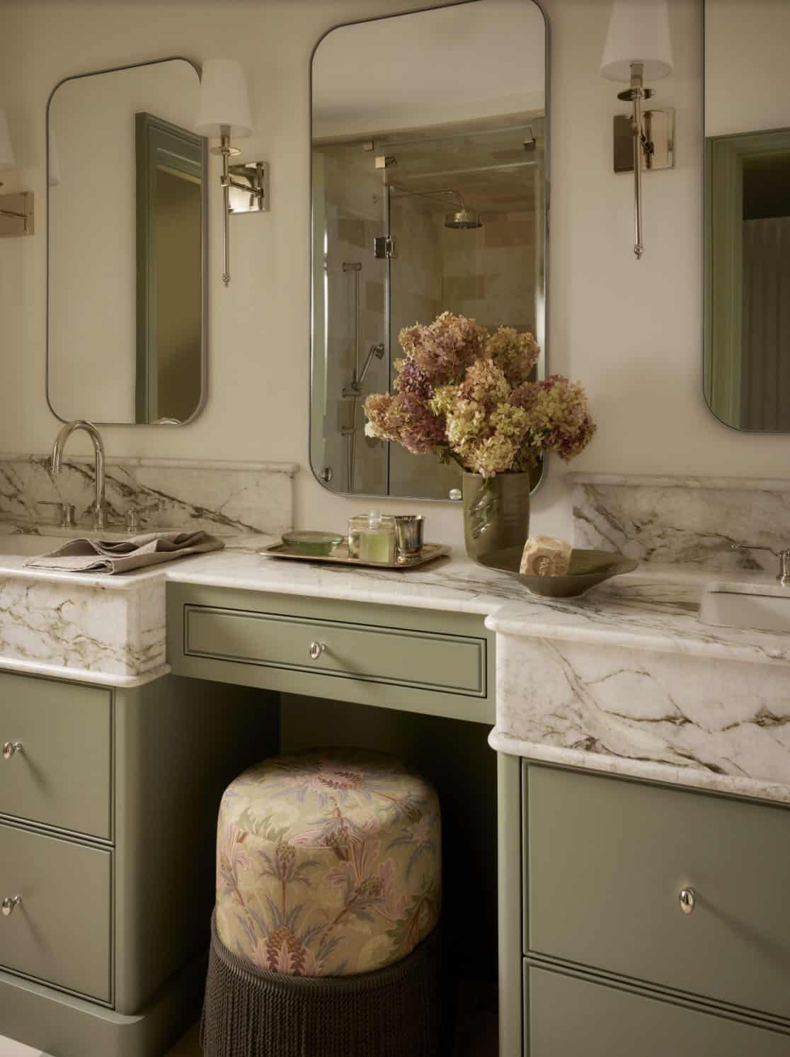 Double vanity with marble counters and floral ottoman
