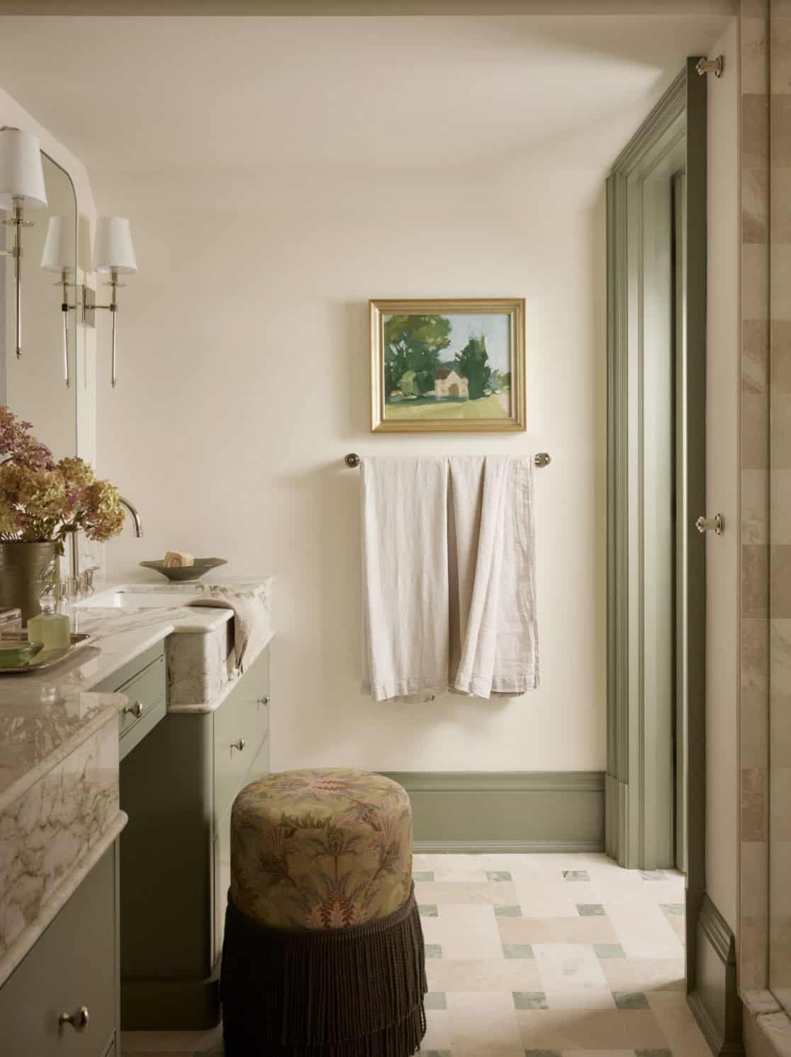 Bathroom hallway with framed landscape art and folded towels