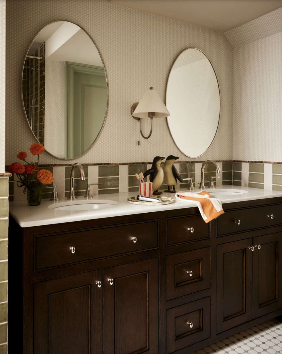 Bathroom double vanity with oval mirrors and green striped tile