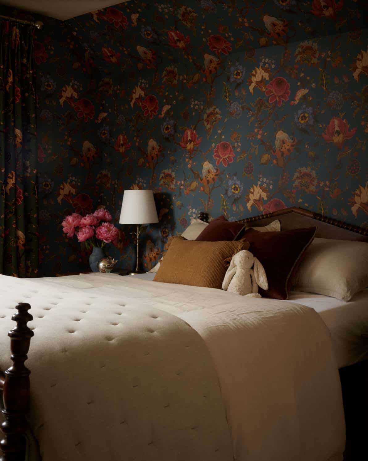 Bedroom with bold floral wallpaper and tufted bedspread