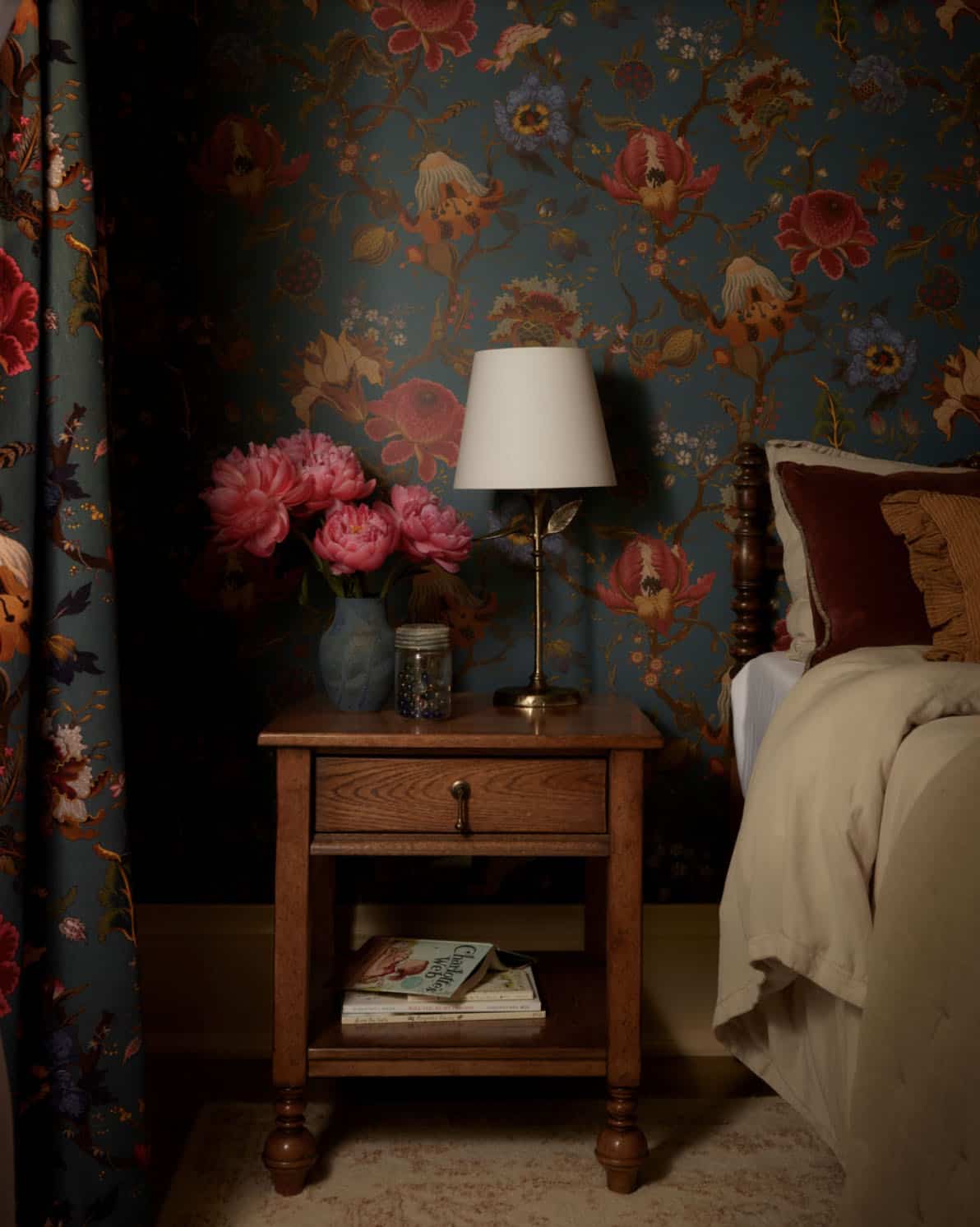 Nightstand vignette against dark floral wallpaper with peonies