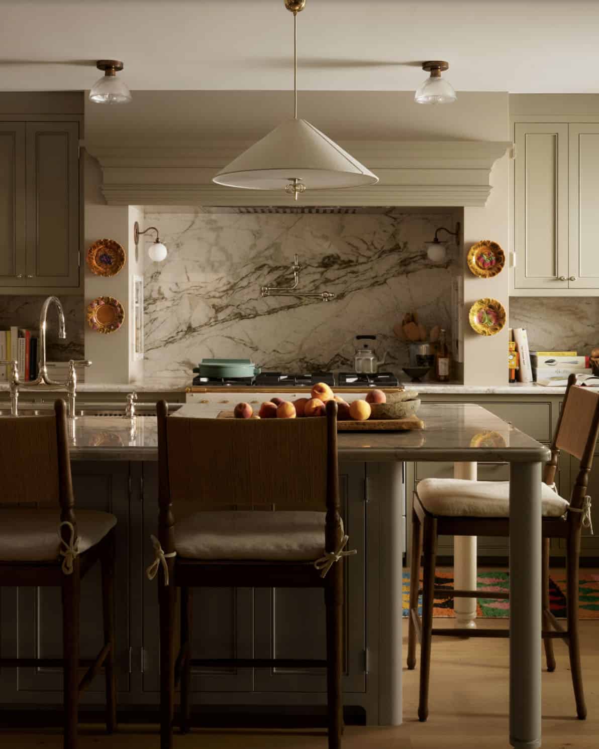 Kitchen island seating with marble backsplash and pendant light