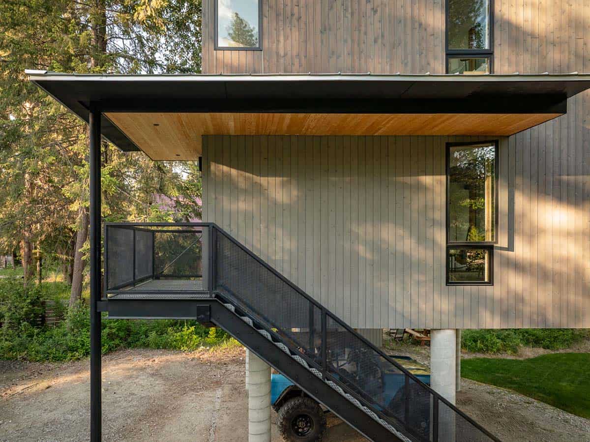 Black steel staircase leading to elevated entry deck of modern Wenatchee River cabin