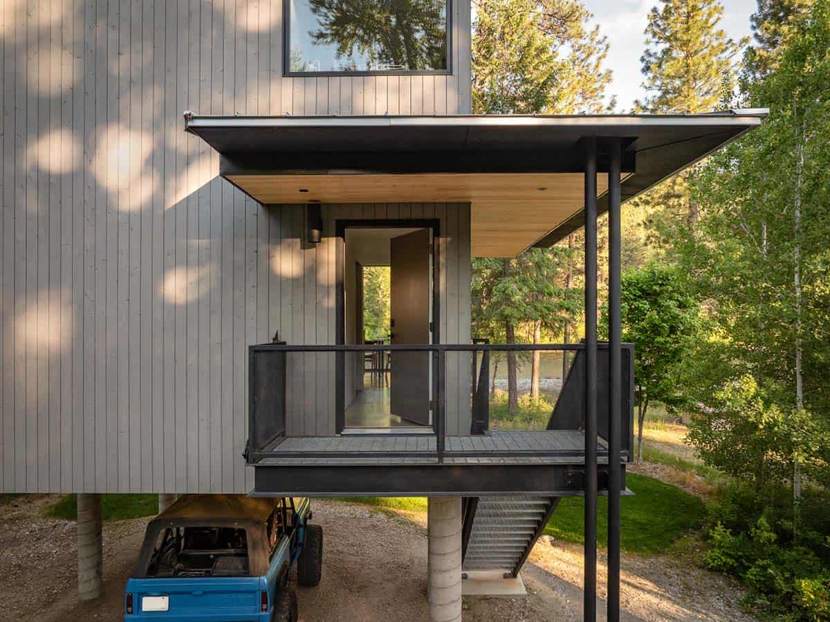Elevated entry porch of modern cabin with wood ceiling and river views beyond
