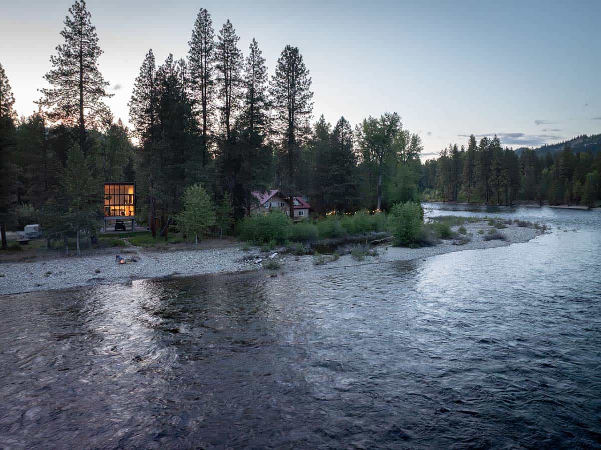 Aerial dusk view of modern cabin and historic farmhouse on Wenatchee River bank
