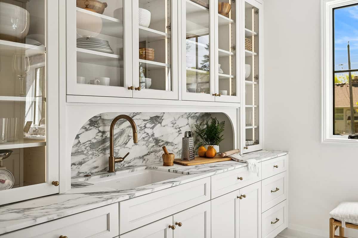 Pantry counter with marble backsplash and brass gooseneck faucet