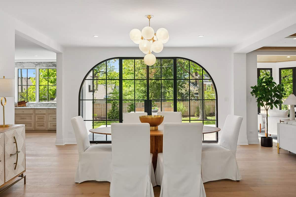 Dining room with round table facing arched steel window