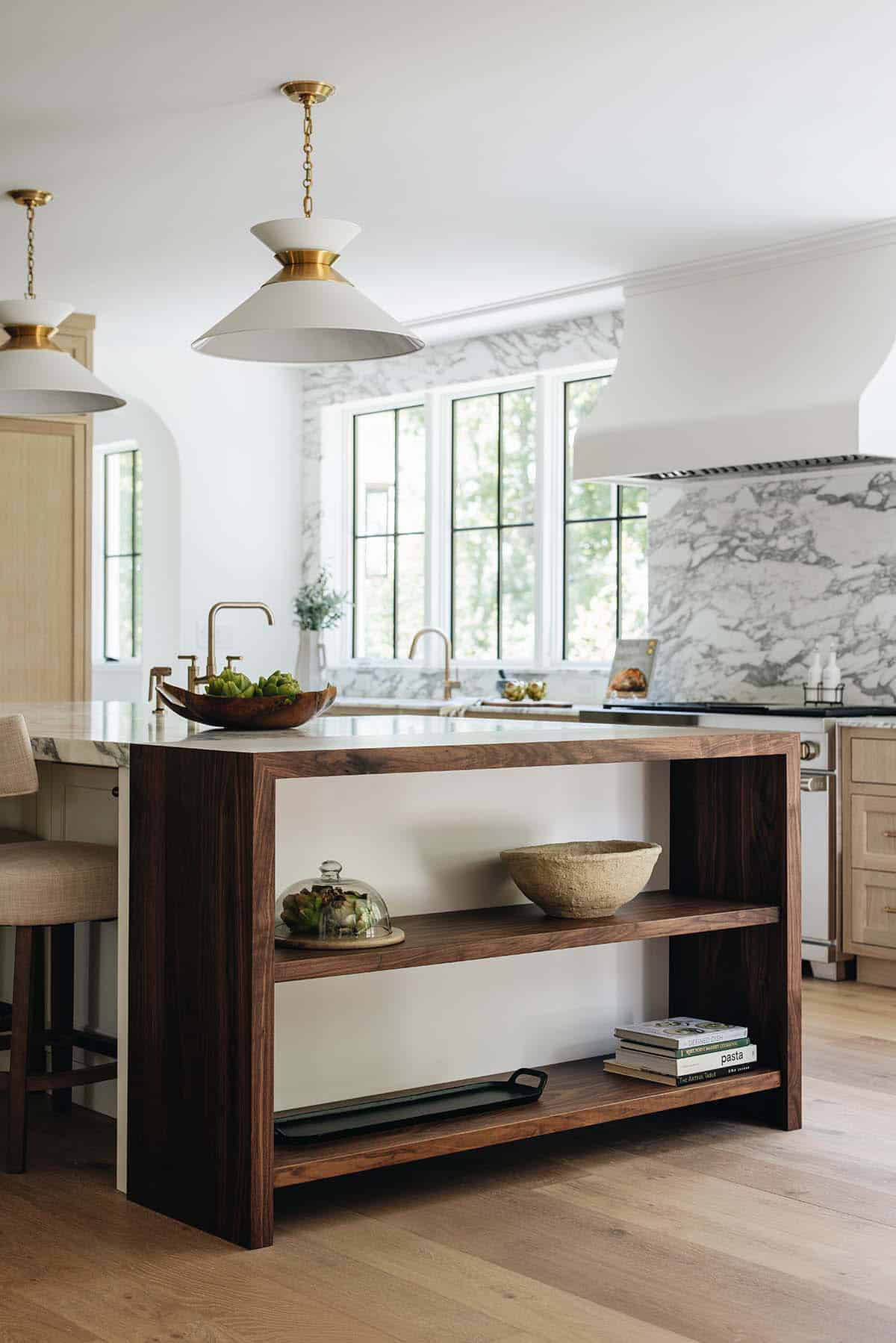 Angled view of walnut kitchen island shelving with artichokes, ceramic bowl, and cookbooks
