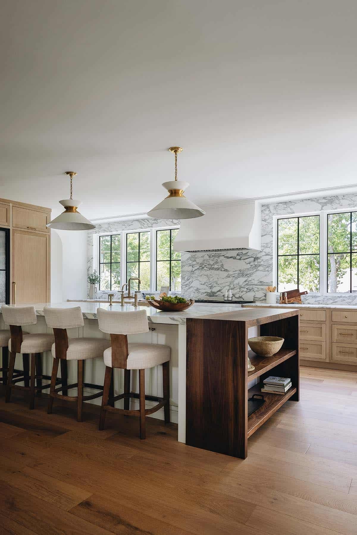 Kitchen island with walnut wood shelving and brass pendant lights