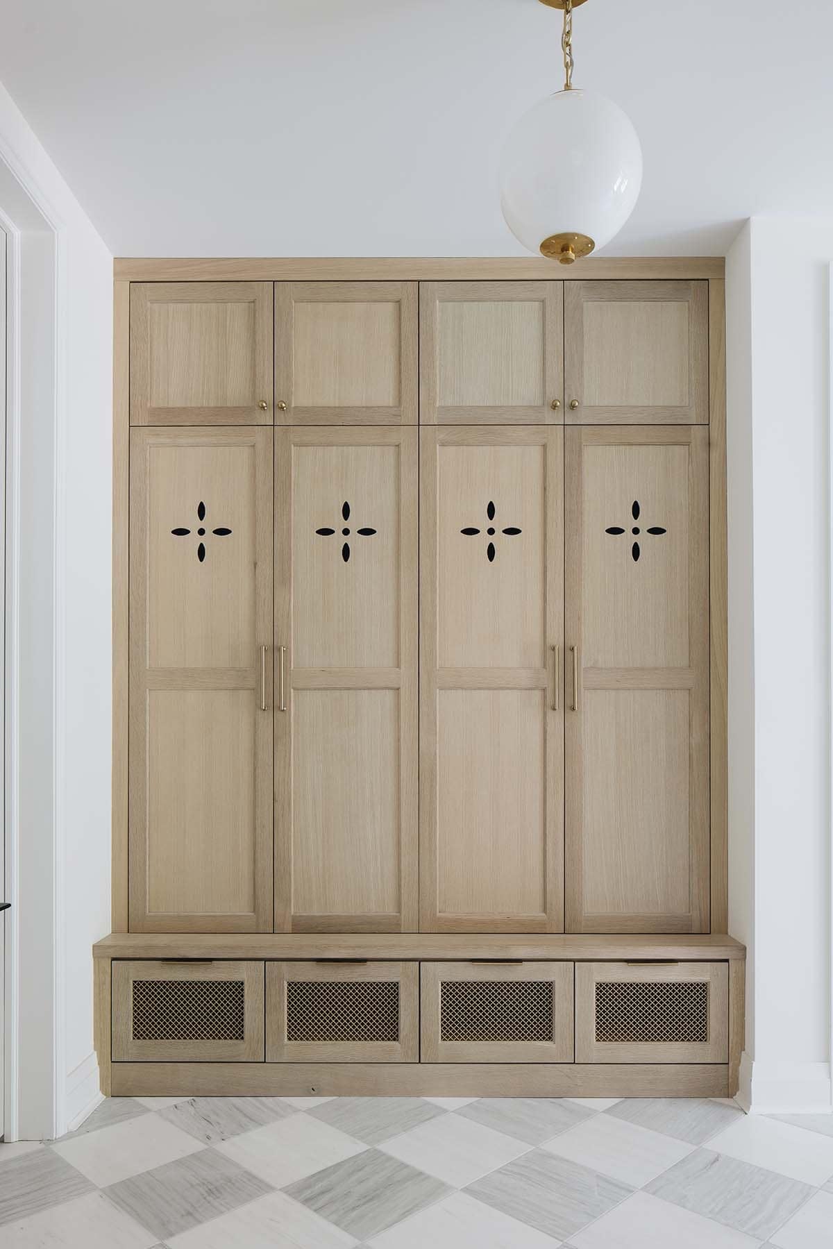 Built in mudroom lockers with brass hardware and cutout details