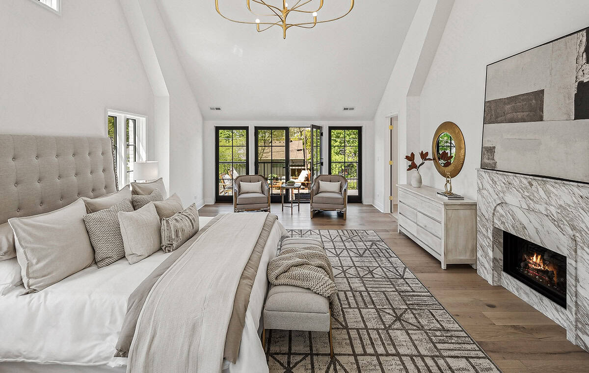 Primary bedroom with tufted headboard and marble fireplace surround