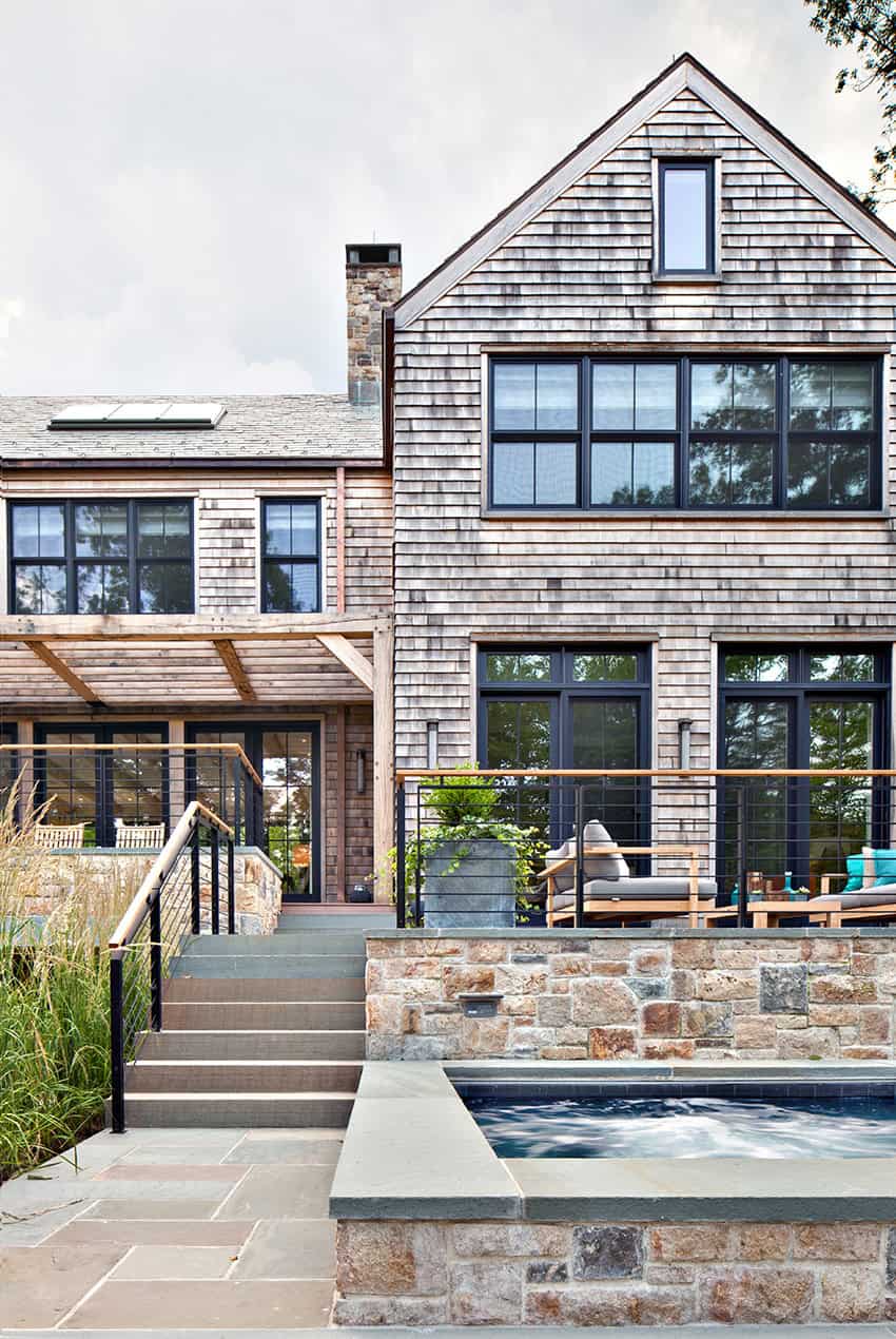 Rear exterior of lake house with stone patio and plunge pool