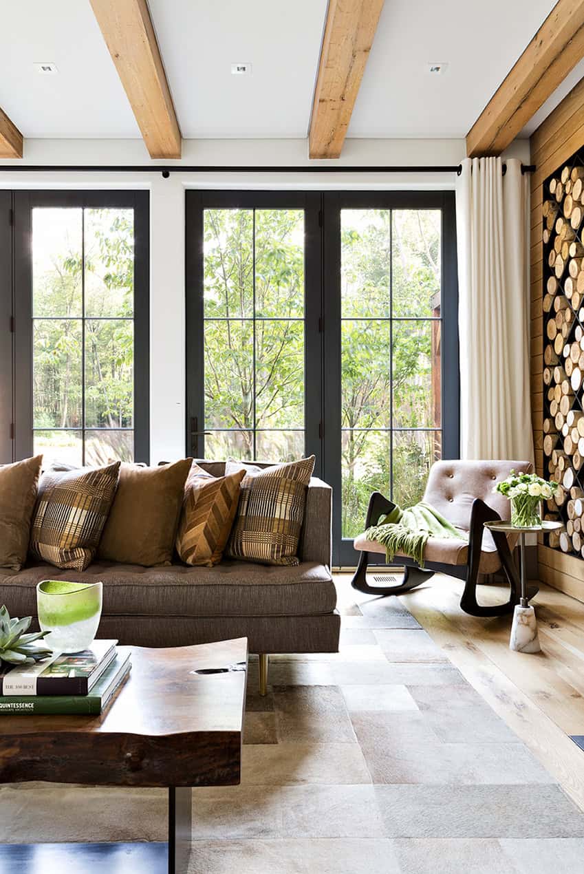 Living room with wood beam ceiling and log wall display