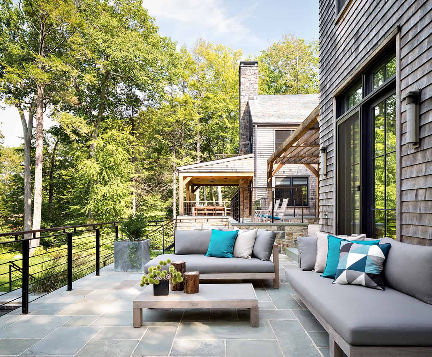 Outdoor patio lounge with gray sofas and teal accent pillows