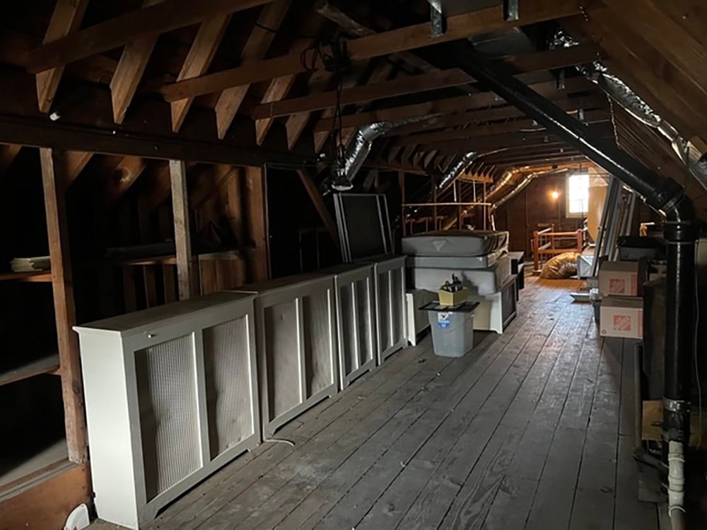 Attic storage space with exposed rafters and built in radiator covers