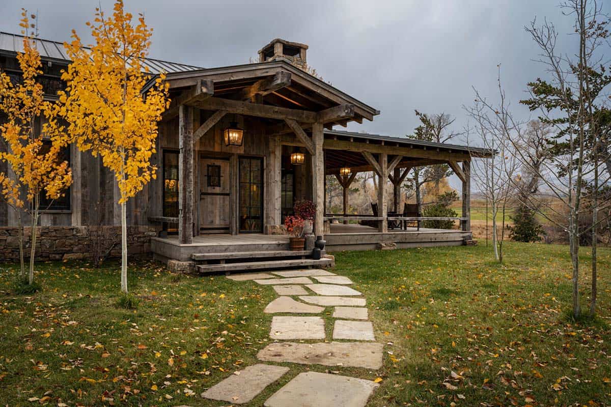 Timber-framed entry porch with flagstone path through aspen trees