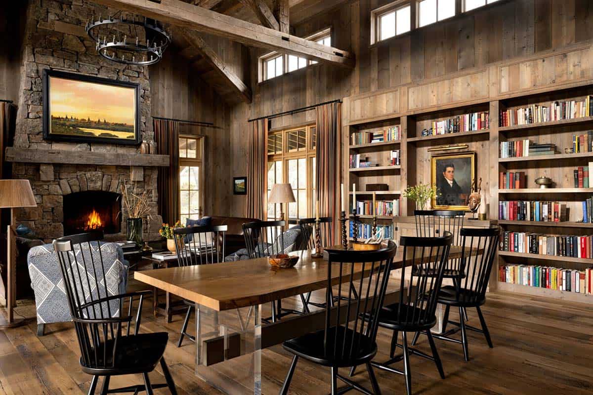 Rustic dining room with stone fireplace, wood beams, and built-in bookshelves