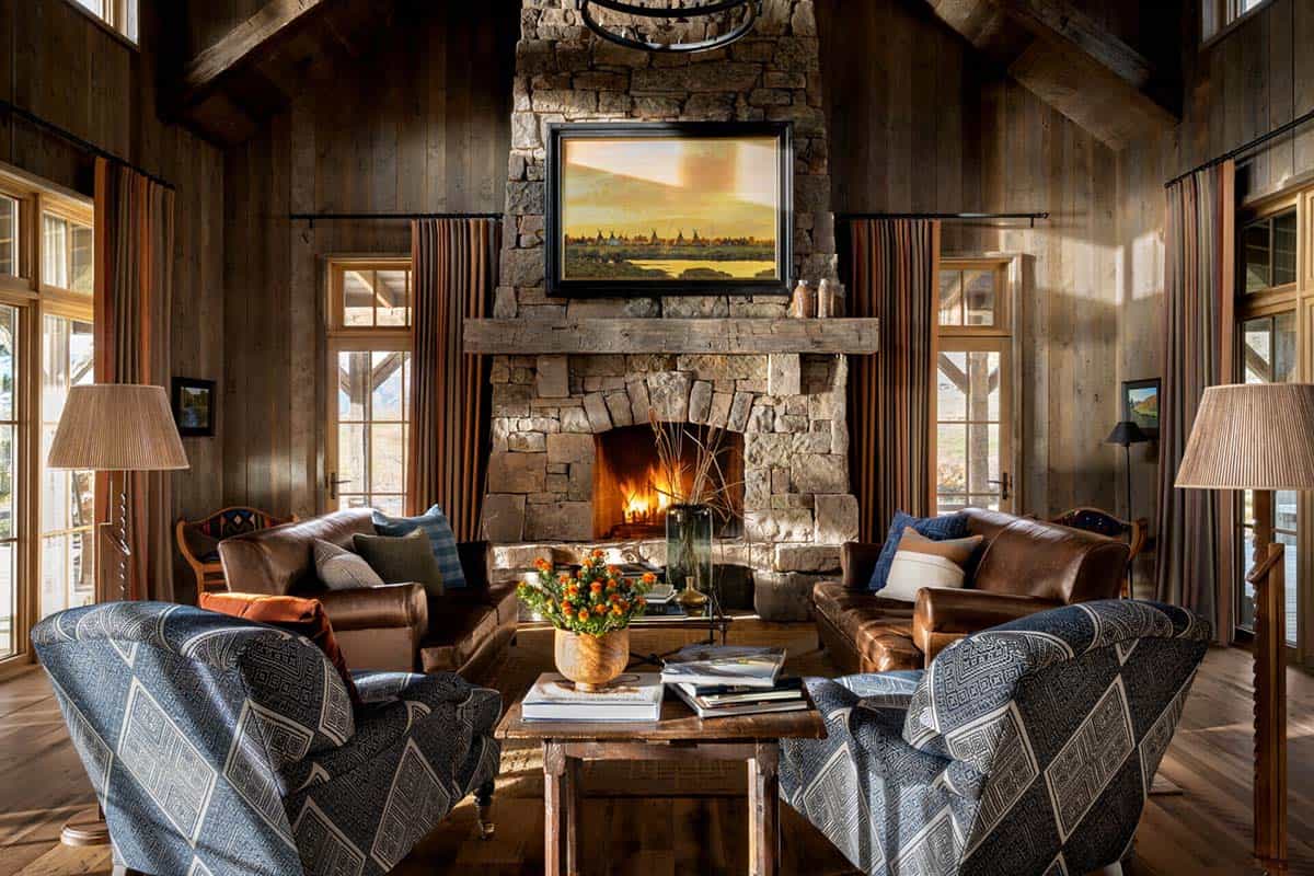 Living room with leather sofas, patterned armchairs, and stone fireplace