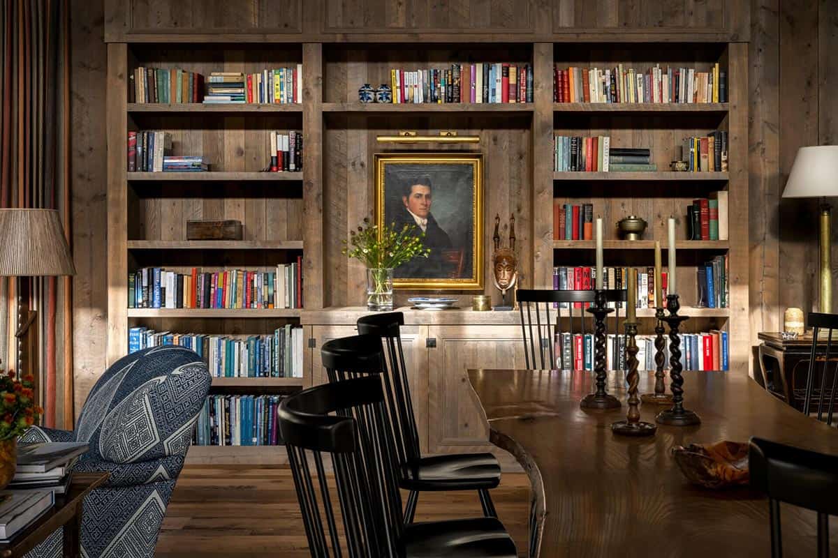 Built-in wood bookshelves with framed portrait and dining table