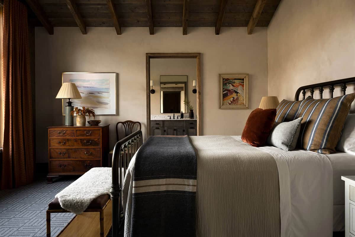 Bedroom with iron bed frame and plaster walls