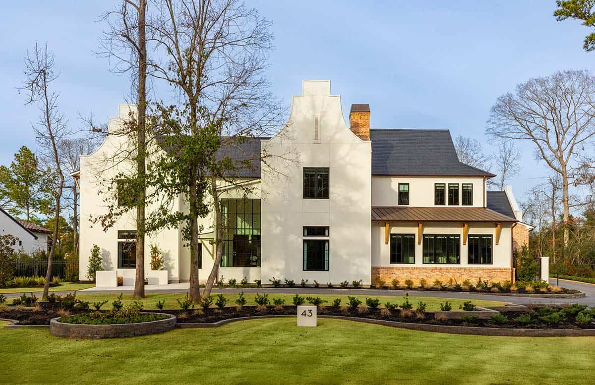 Cape Dutch-style home exterior with curved gable and slate roof, front lawn view