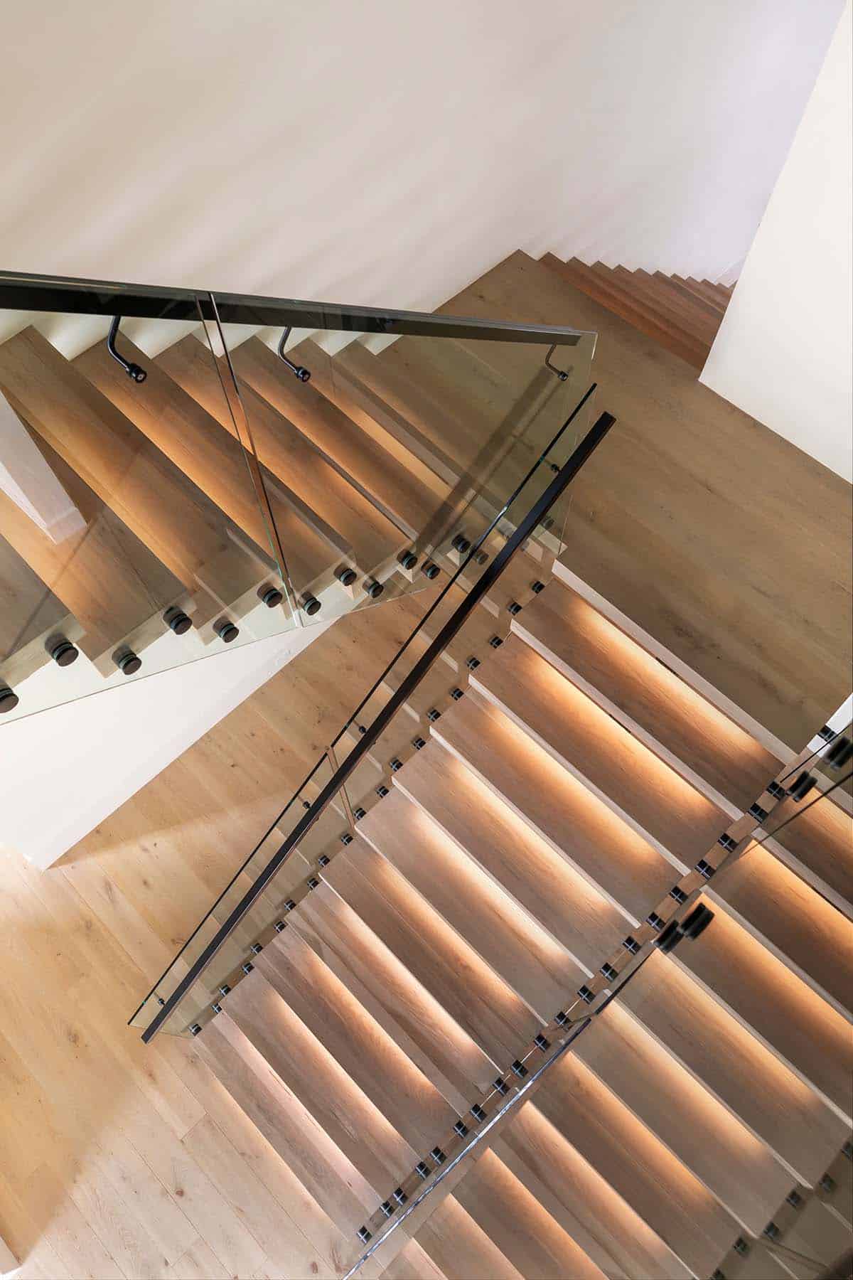 Overhead view of floating wood stair treads with glass railing