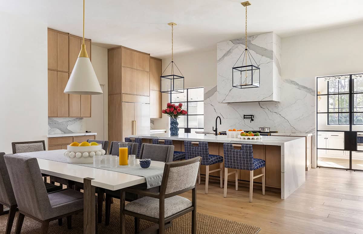 Open kitchen and dining area with marble island and blue patterned barstools