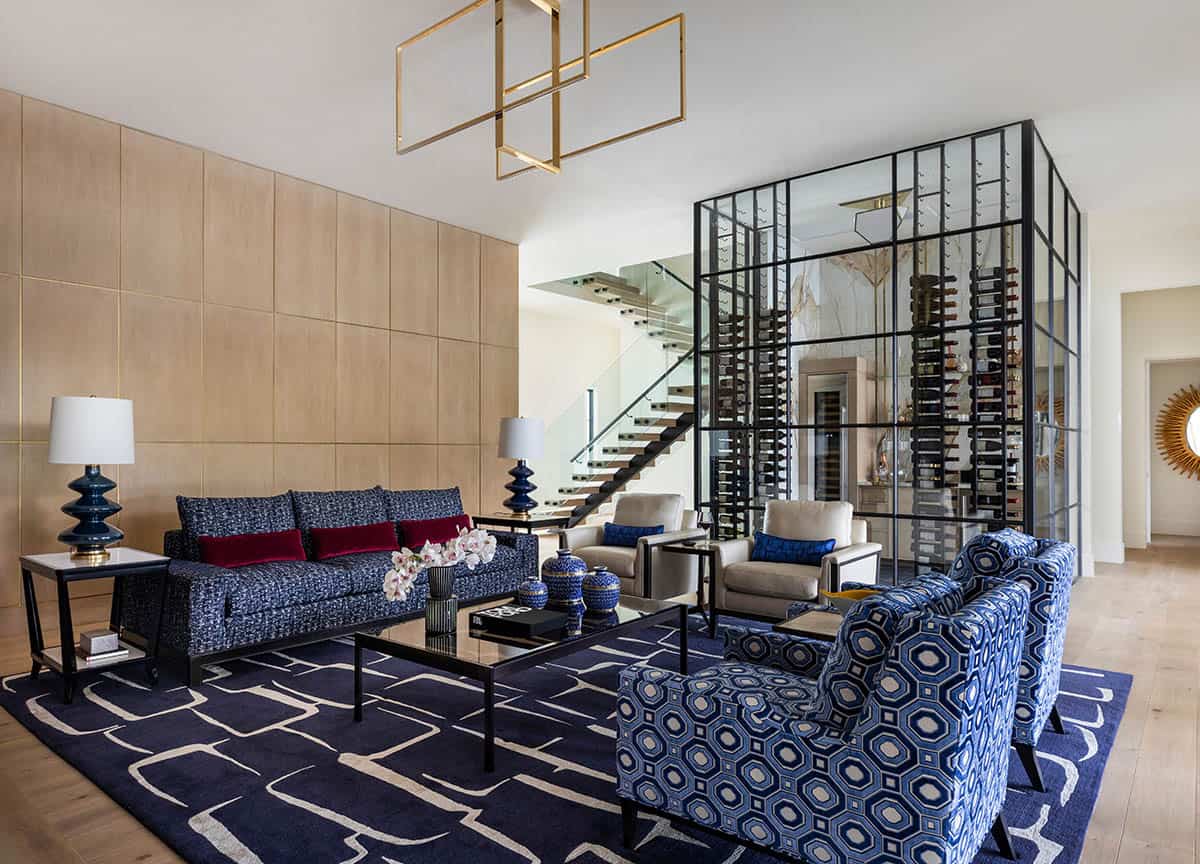 Living room with navy patterned rug, blue sofa, and glass wine display
