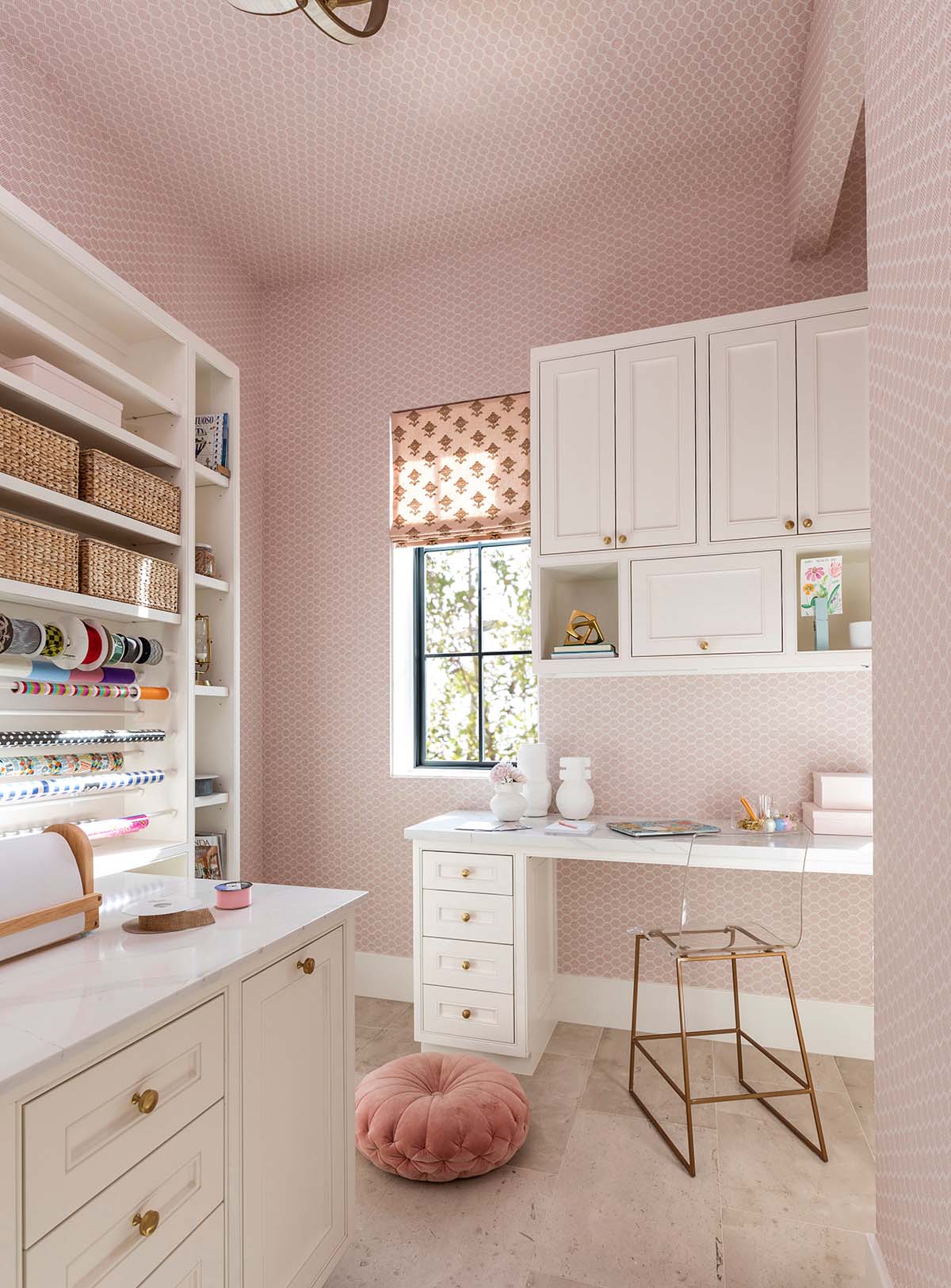 Pink craft room with wrapping paper storage and built-in desk