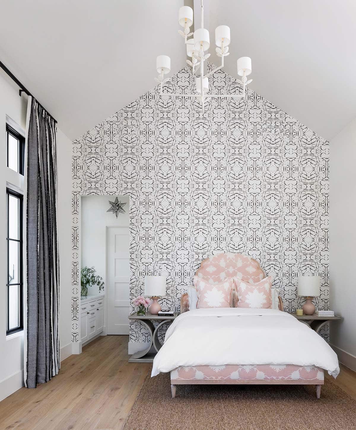 Girl's bedroom with peaked wallpapered wall and pink upholstered bed