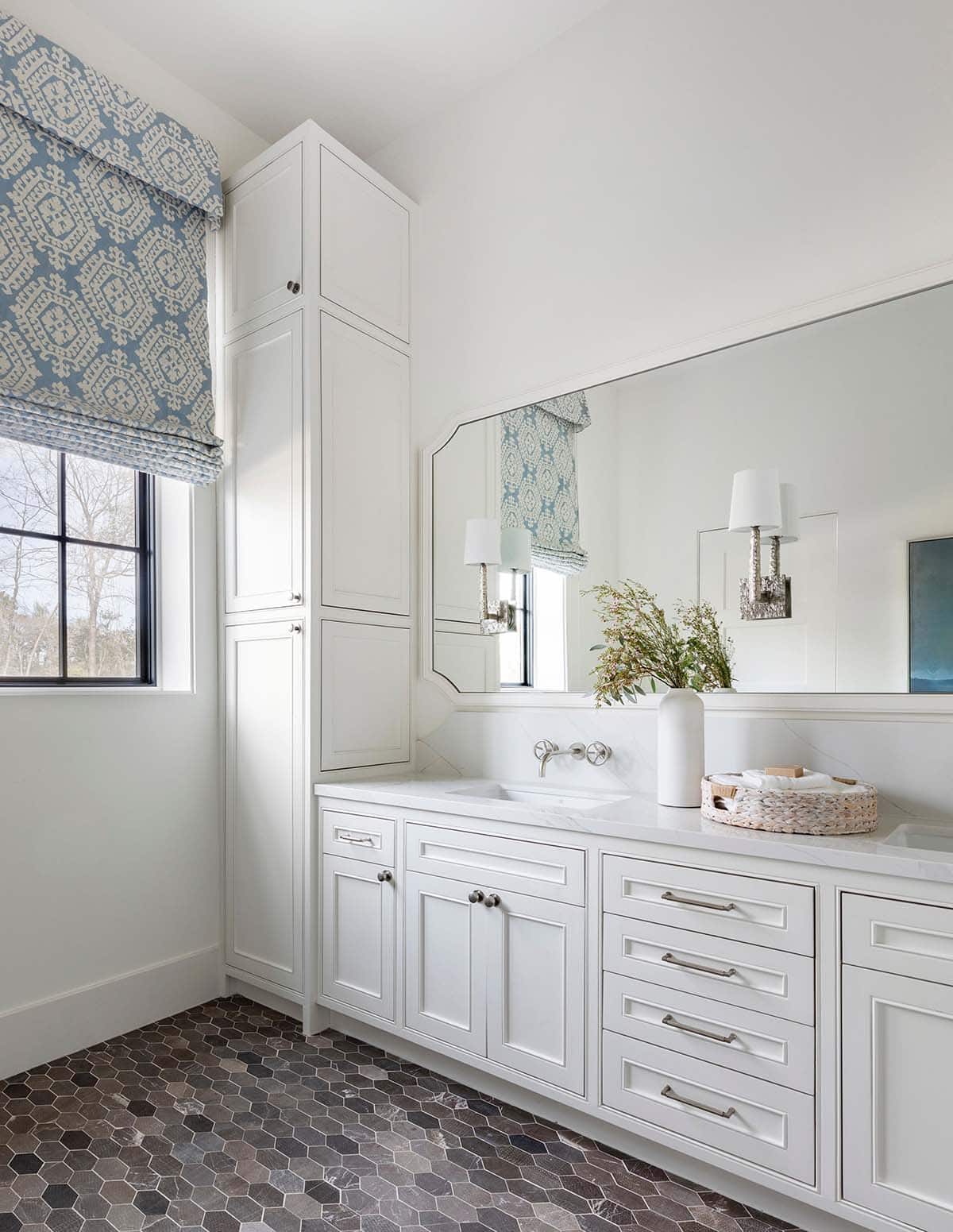 Bathroom vanity with blue roman shade and hexagon tile floor