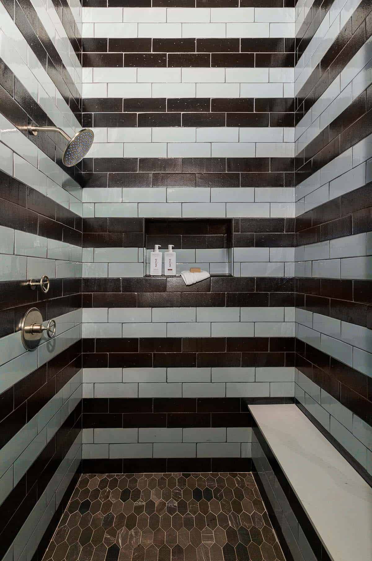 Striped black and white subway tile shower with built-in niche