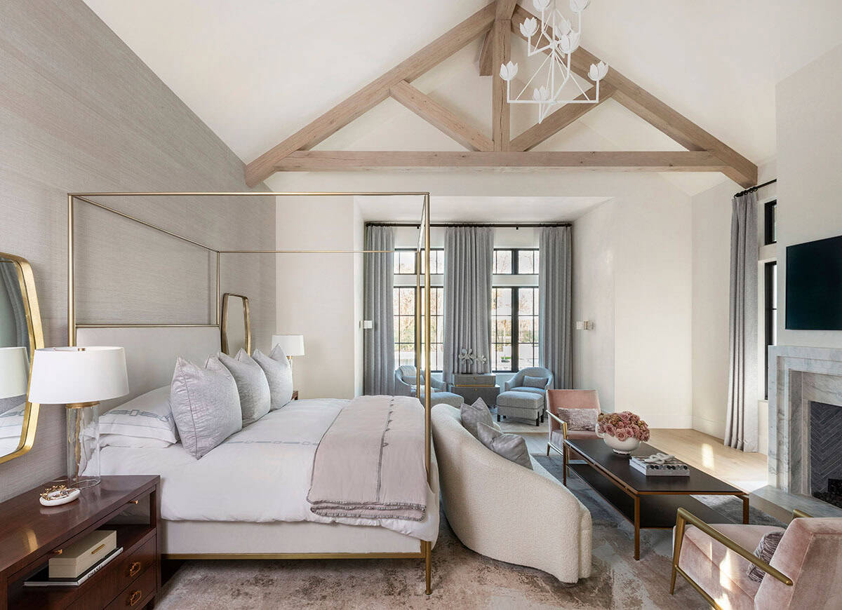 Primary bedroom with brass canopy bed and vaulted wood beam ceiling