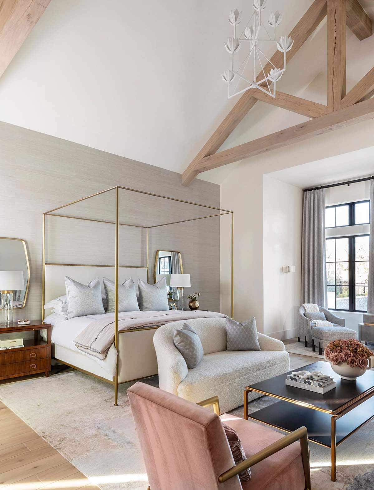 Primary bedroom with canopy bed, boucle sofa, and gray grasscloth wall