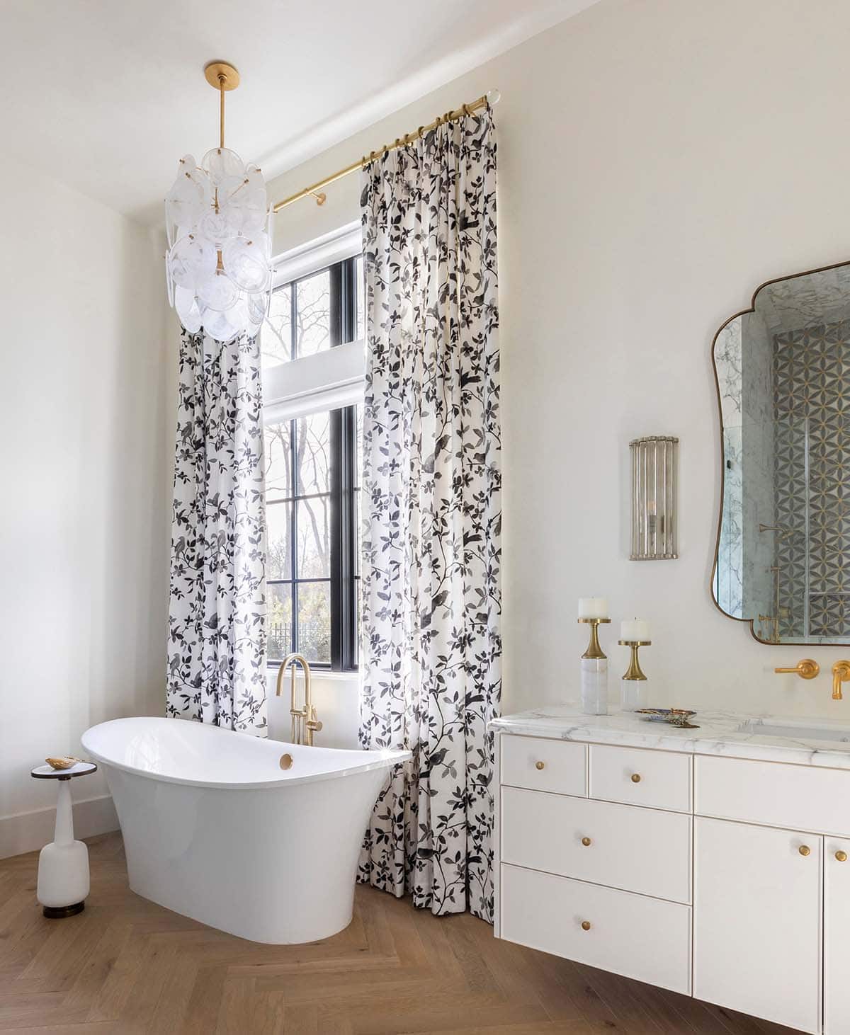 Freestanding tub with bird-print curtains and bubble glass chandelier
