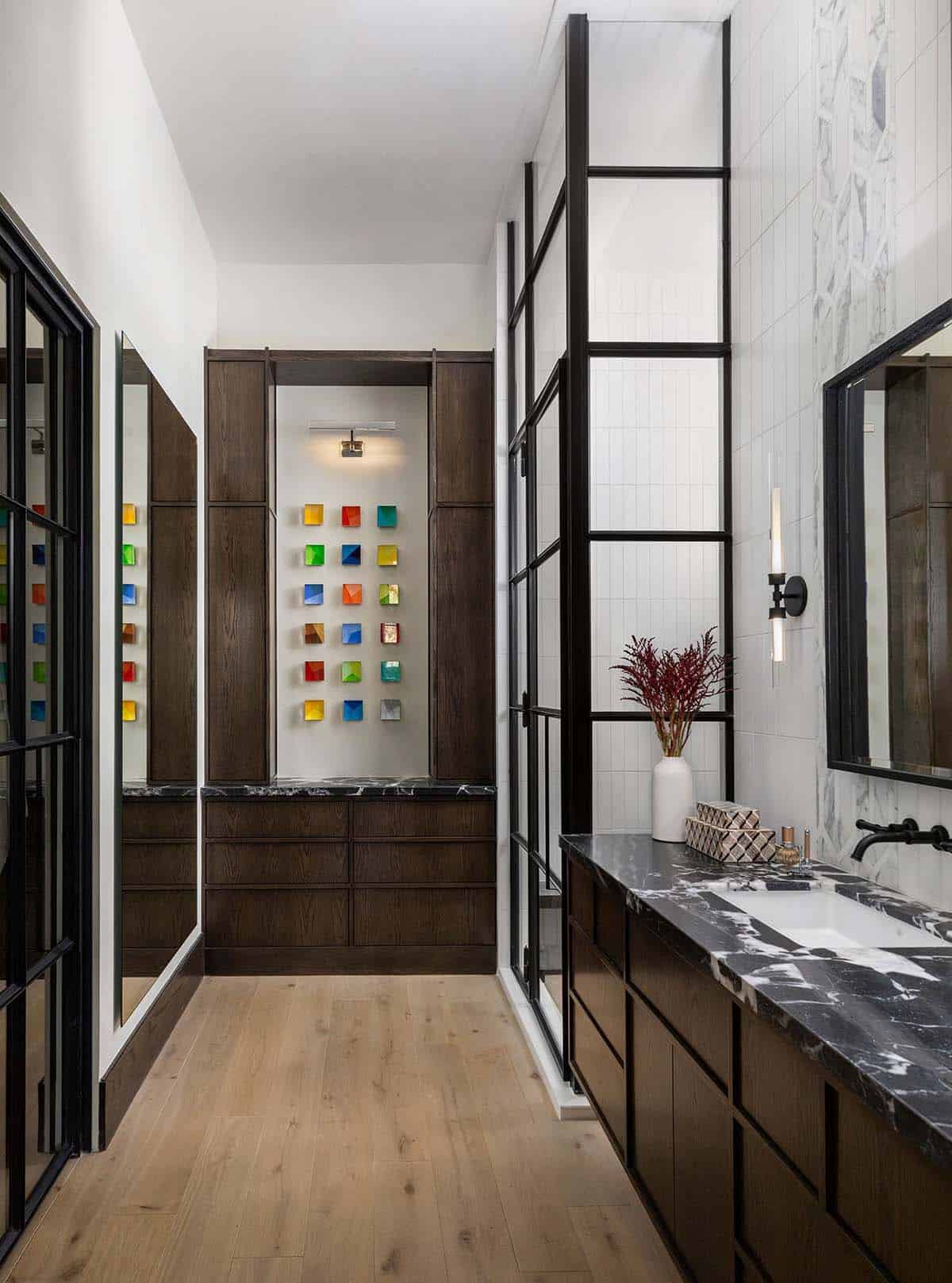 Bathroom hallway with dark wood cabinetry and colorful glass art squares