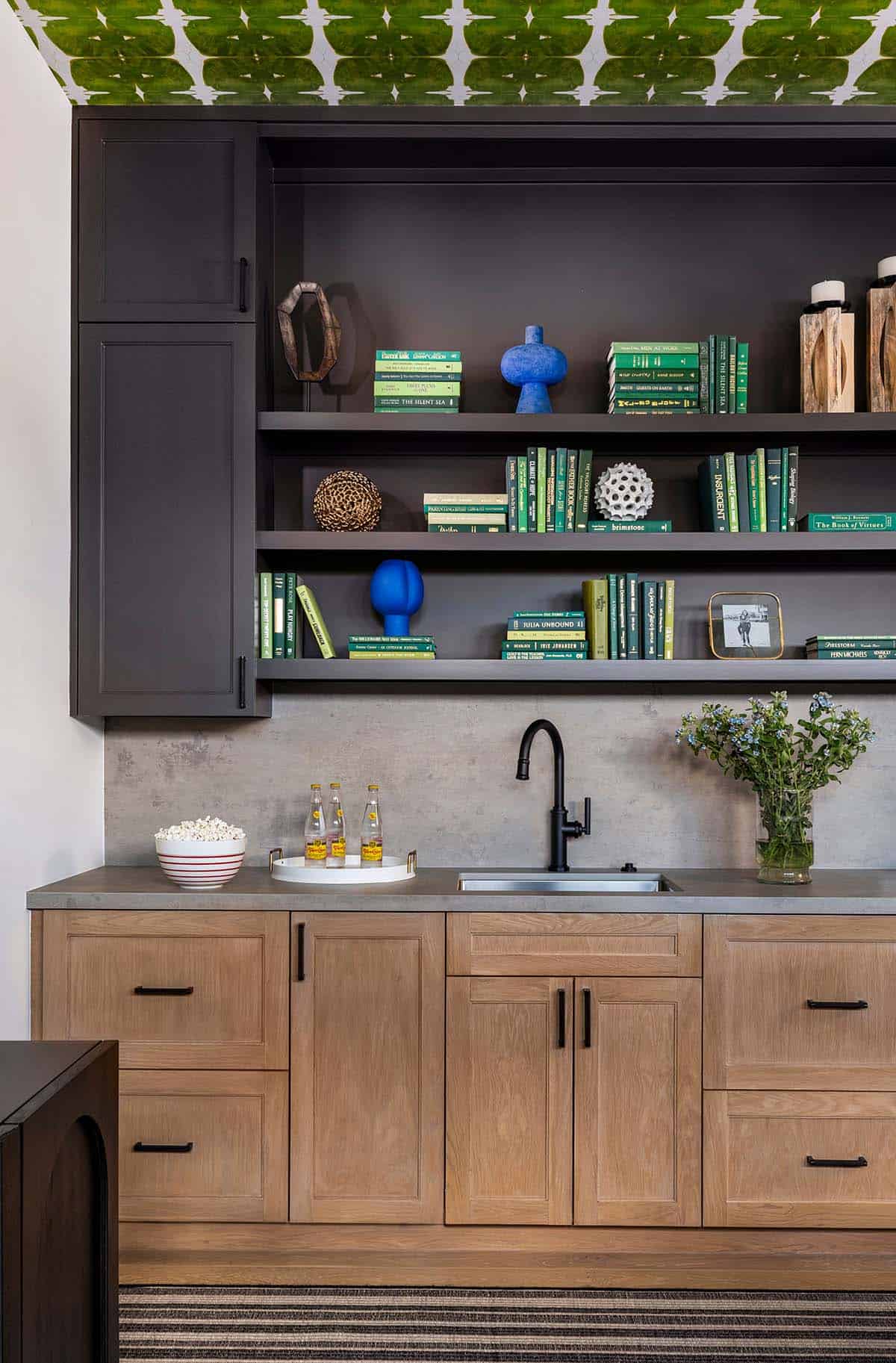 Wet bar shelves with green books and green mosaic tile backsplash