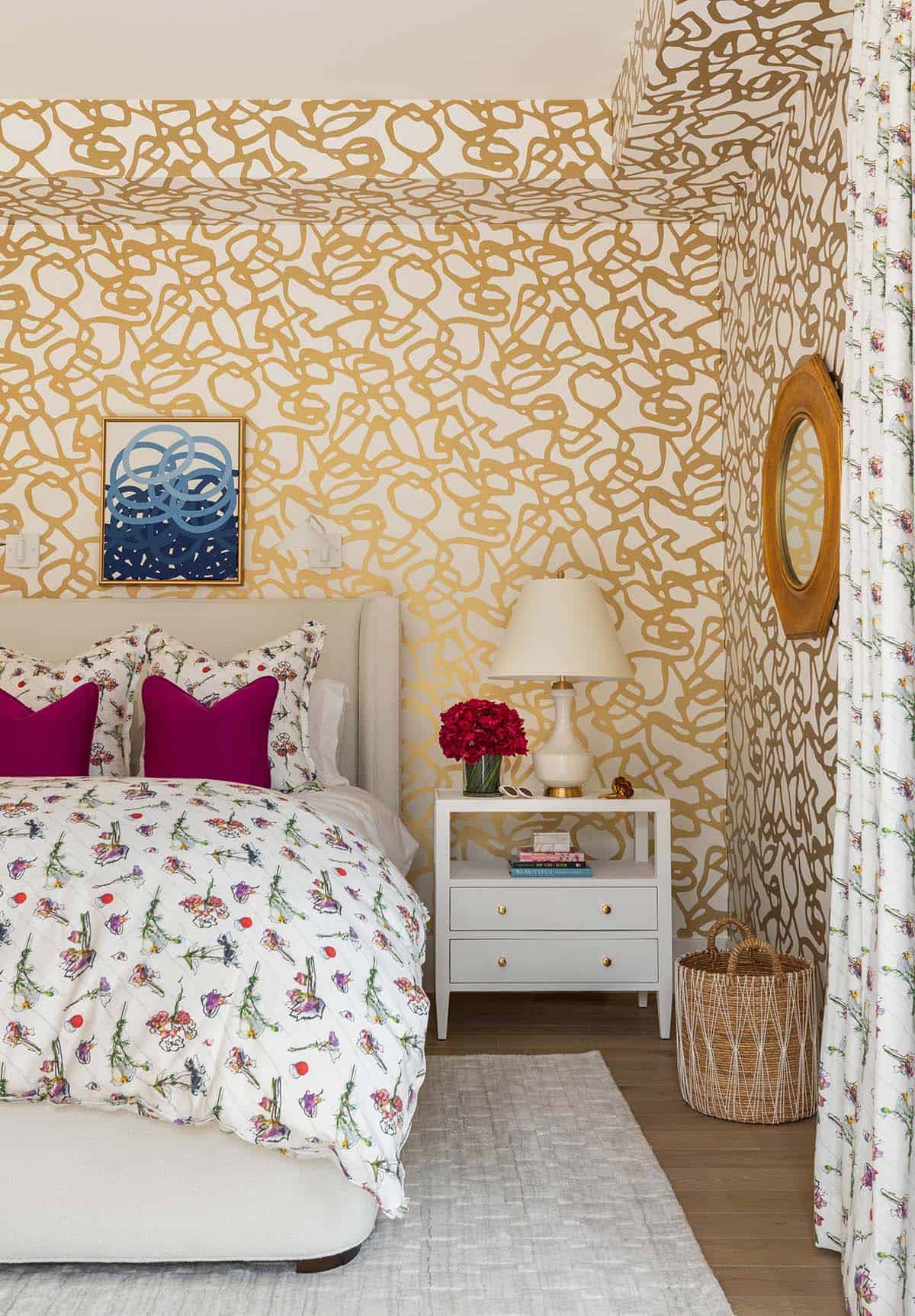 Bedroom corner with gold squiggle wallpaper and pink and blue bedding