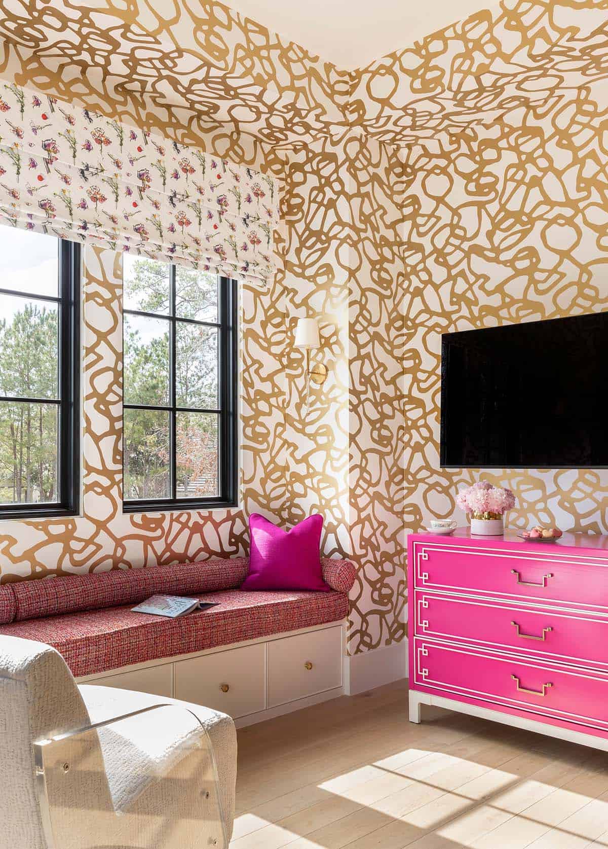 Kids room with gold wallpaper, hot pink dresser, and tweed bench