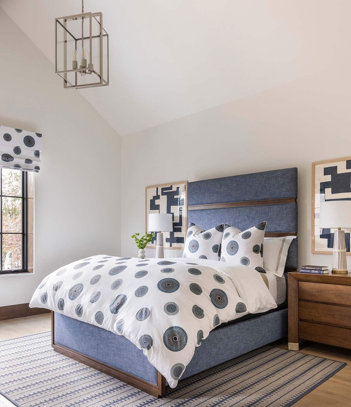 Bedroom with blue upholstered bed and polka dot bedding